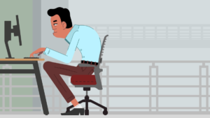 Tired man slumped at a desk, typing on a computer in a modern office.