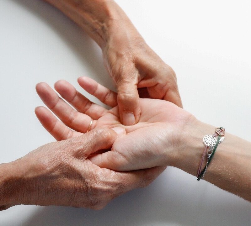 Two hands clasped in a comforting, supportive gesture on a white background.