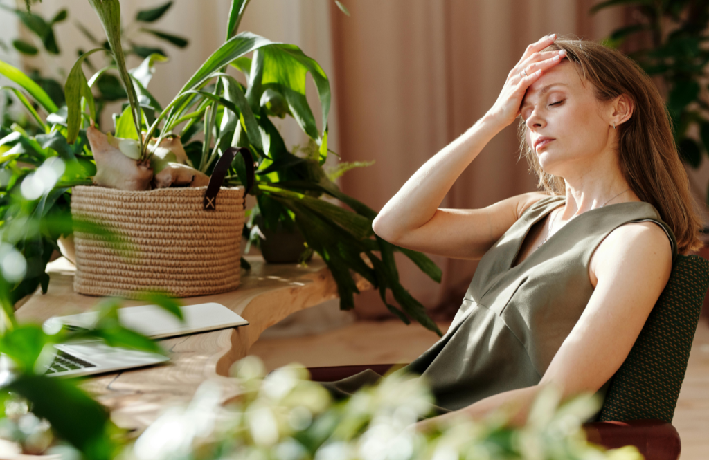 woman with headache holding head