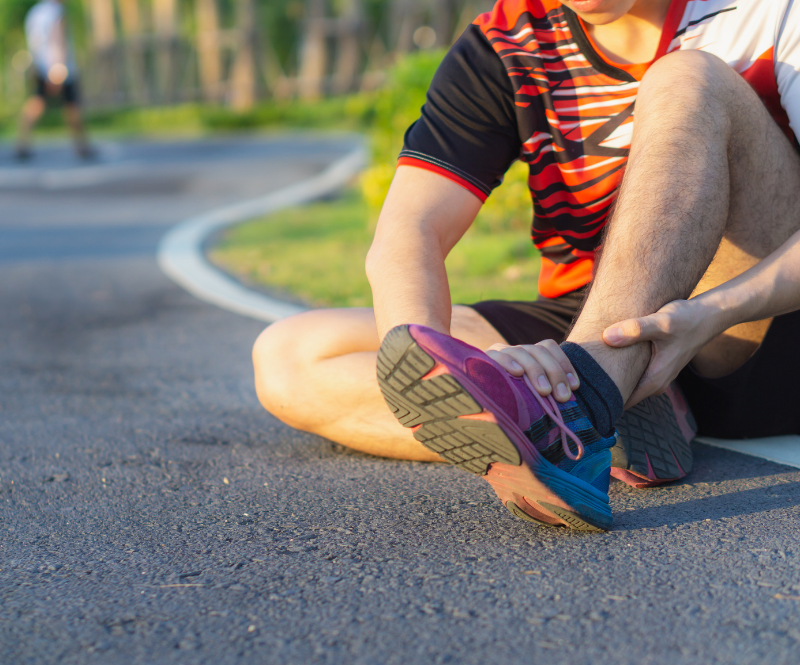 man holding a rolled ankle ligament sprain