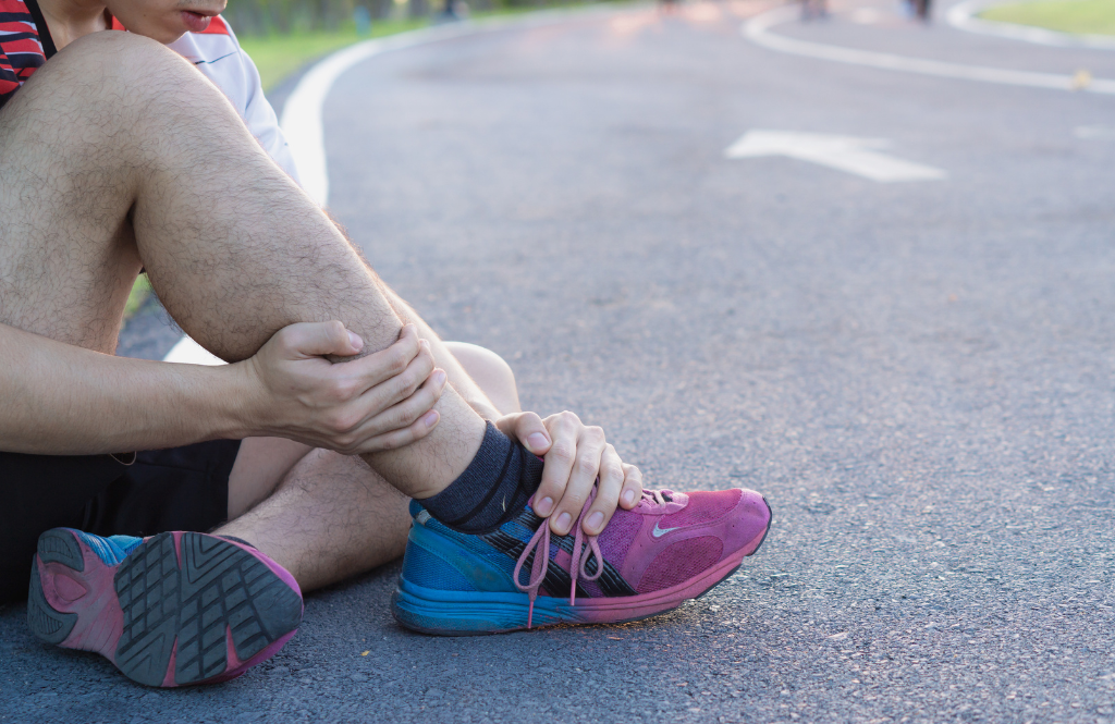 person holding a sore ankle after running
